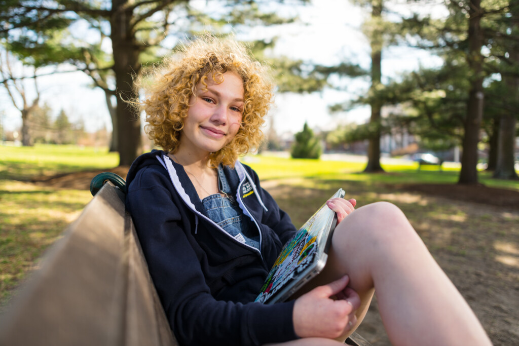 Precollege student on UVM campus bench