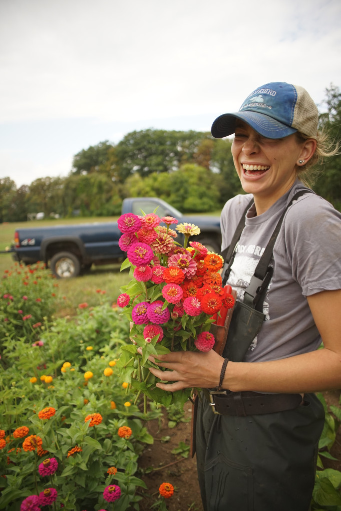 woman smiling with flowers in hand at farm