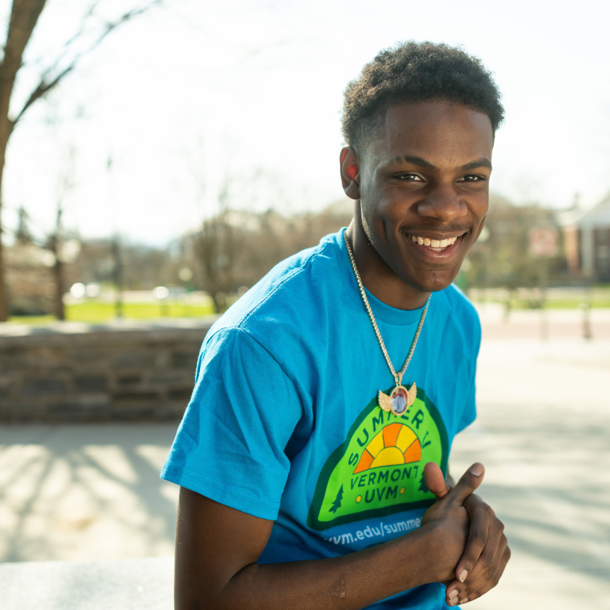 precollege student Alonzo in blue t-shirt smiling on campus