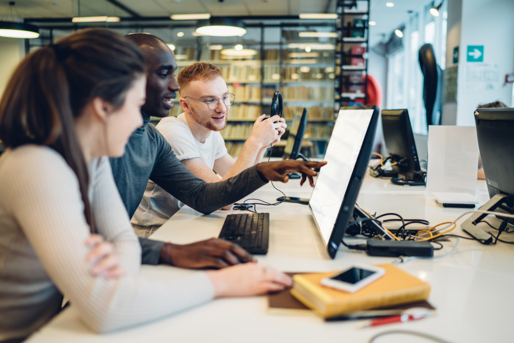 three students looking at computer