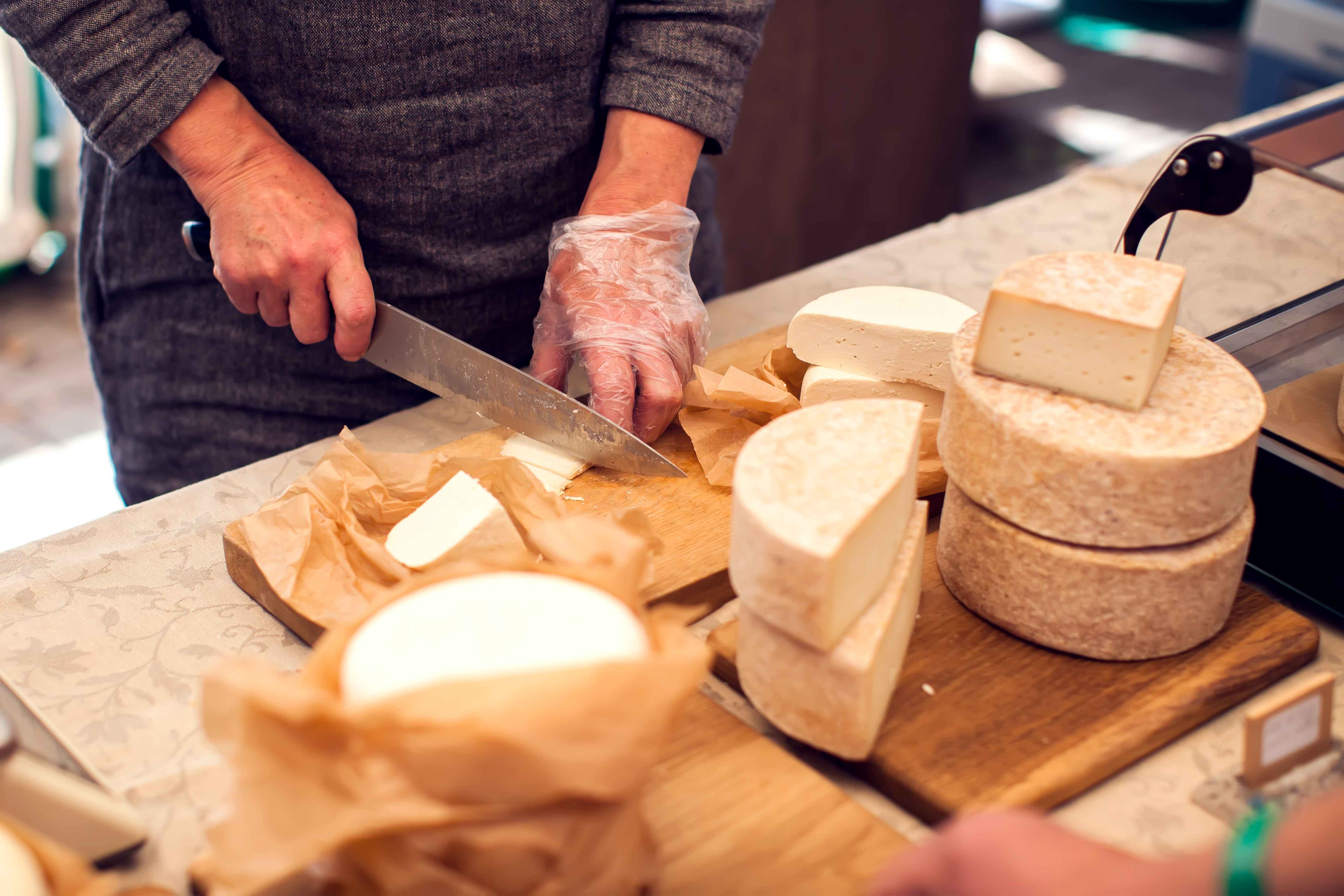 Man is a cheese maker in the process of producing different varieties of  cheese in the industry. Milk cheese making Photos