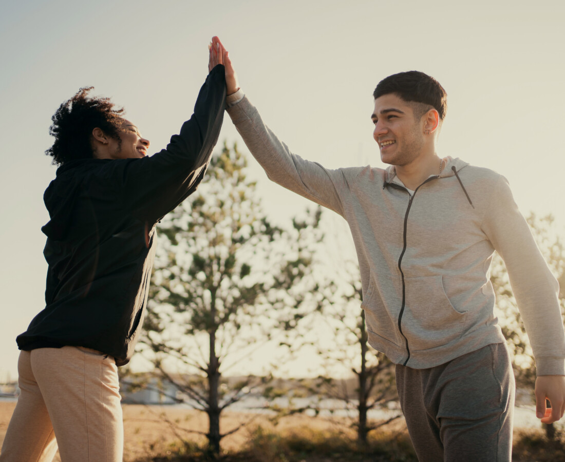 two athletes make a greeting with their hands a woman and a man Young sports couple friends are engaged in fitness on the street early in the morning lead a healthy lifestyle and proper nutrition