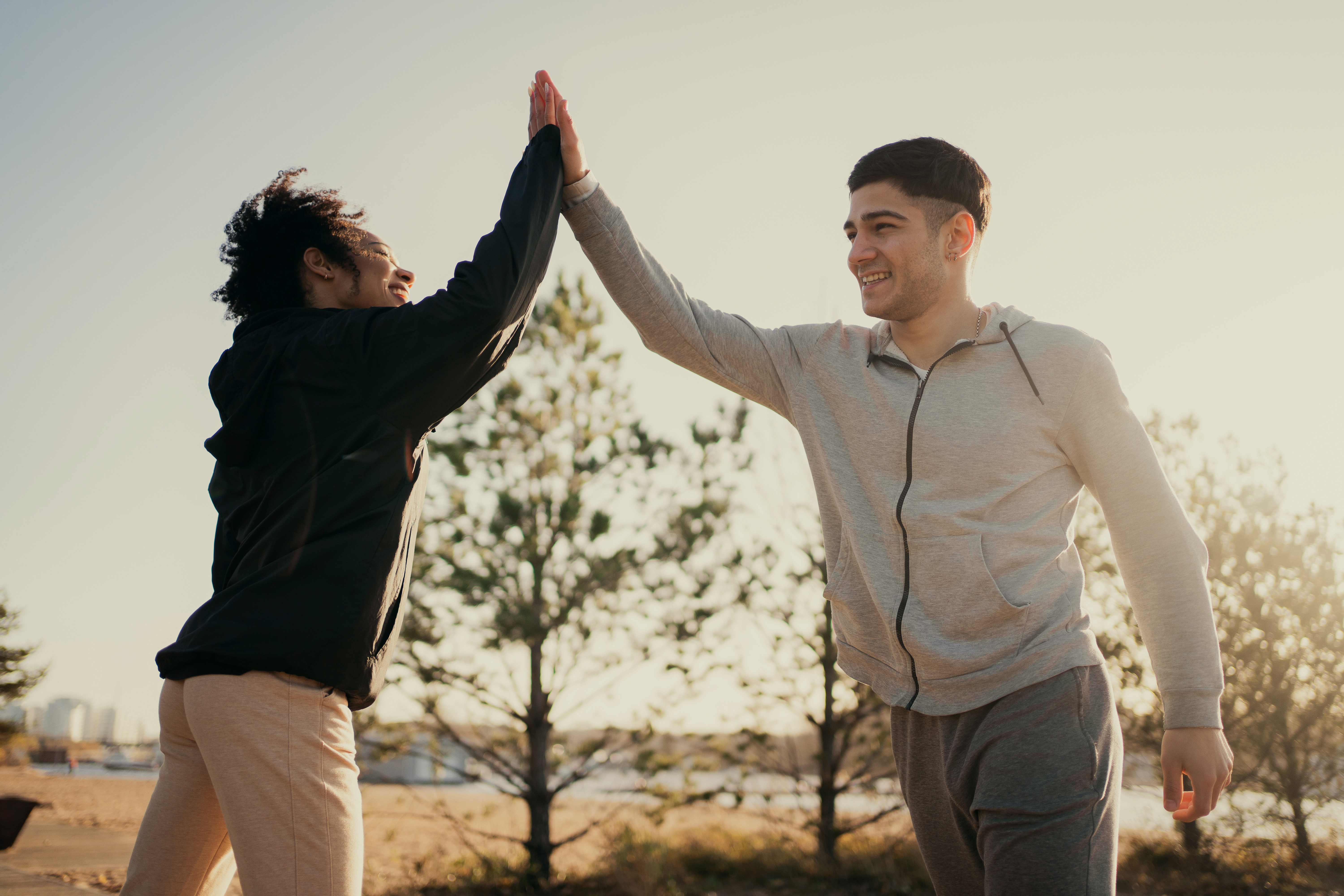 two athletes make a greeting with their hands a woman and a man Young sports couple friends are engaged in fitness on the street early in the morning lead a healthy lifestyle and proper nutrition