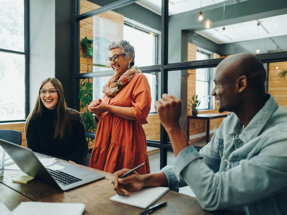 Diverse business people smiling cheerfully during an office meeting