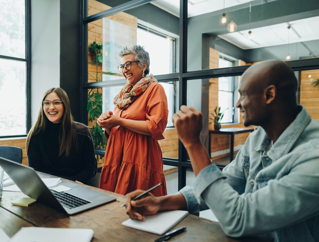 Diverse business people smiling cheerfully during an office meeting
