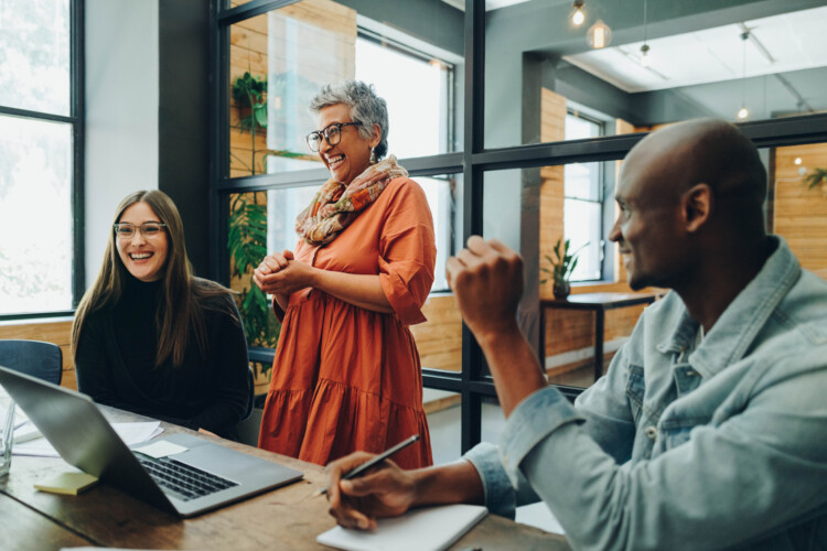 Diverse business people smiling cheerfully during an office meeting
