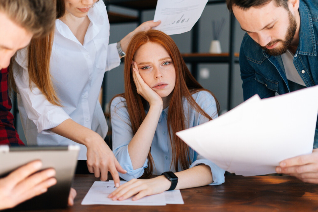 Close-up of exhausted overworked young business woman under stress at office.