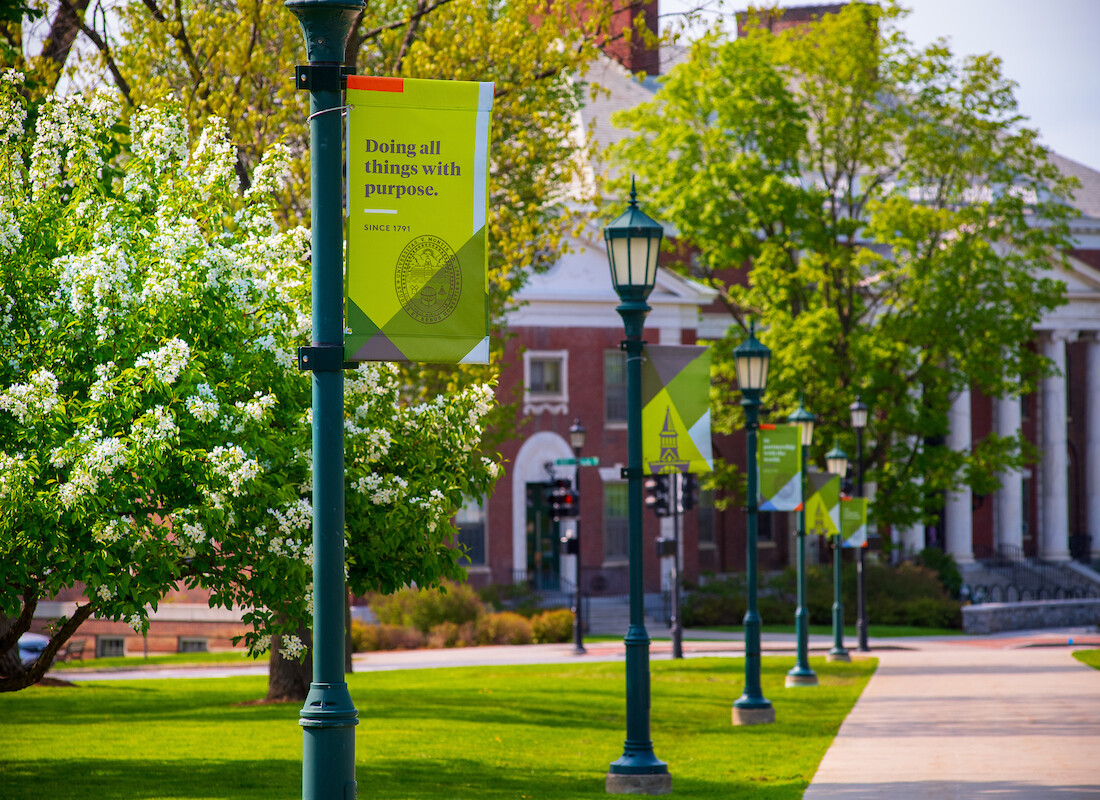 UVM Campus with sign Doing all things with purpose