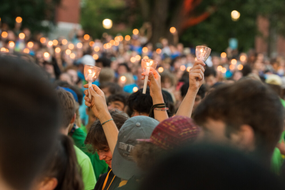 uvm students holding candles in air