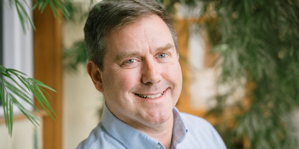 Daniel Erickson smiling wearing a blue collared shirt