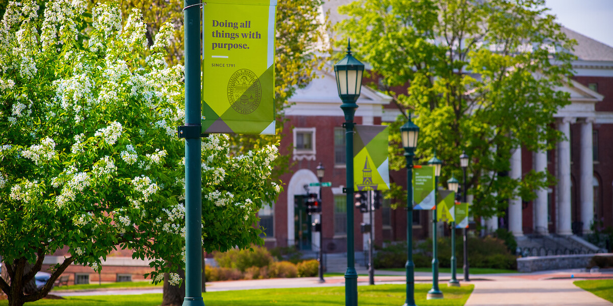 UVM Campus with sign Doing all things with purpose