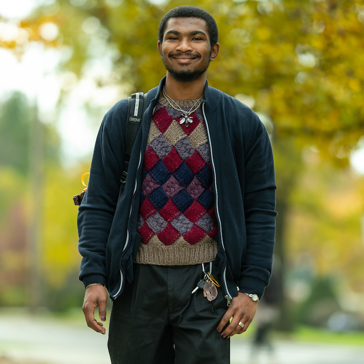 Ayden Carpenter smiling while walking in a campus environment