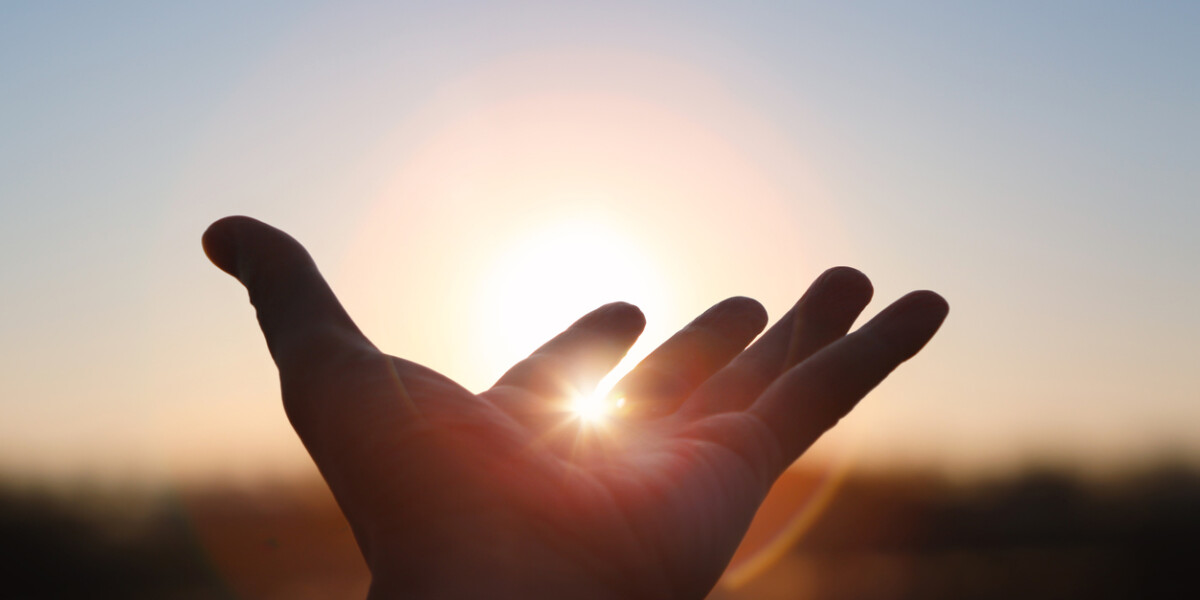 Hands stretched out toward the rising sun