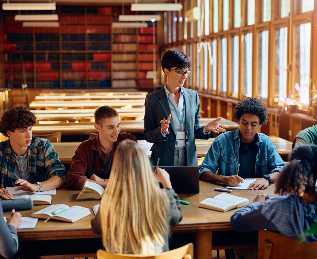 School Library Media Specialist giving a lecture to group of students in library.