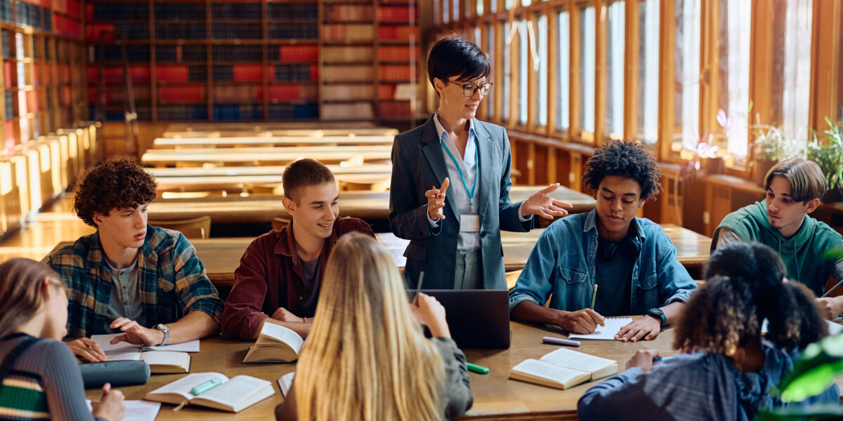 School Library Media Specialist giving a lecture to group of students in library.