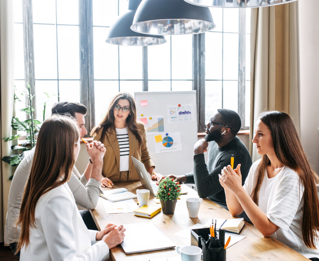 Group of professionals in an office working around a table.