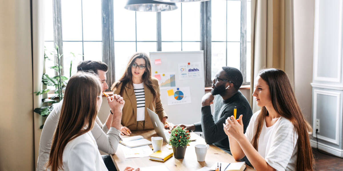 Group of professionals in an office working around a table.