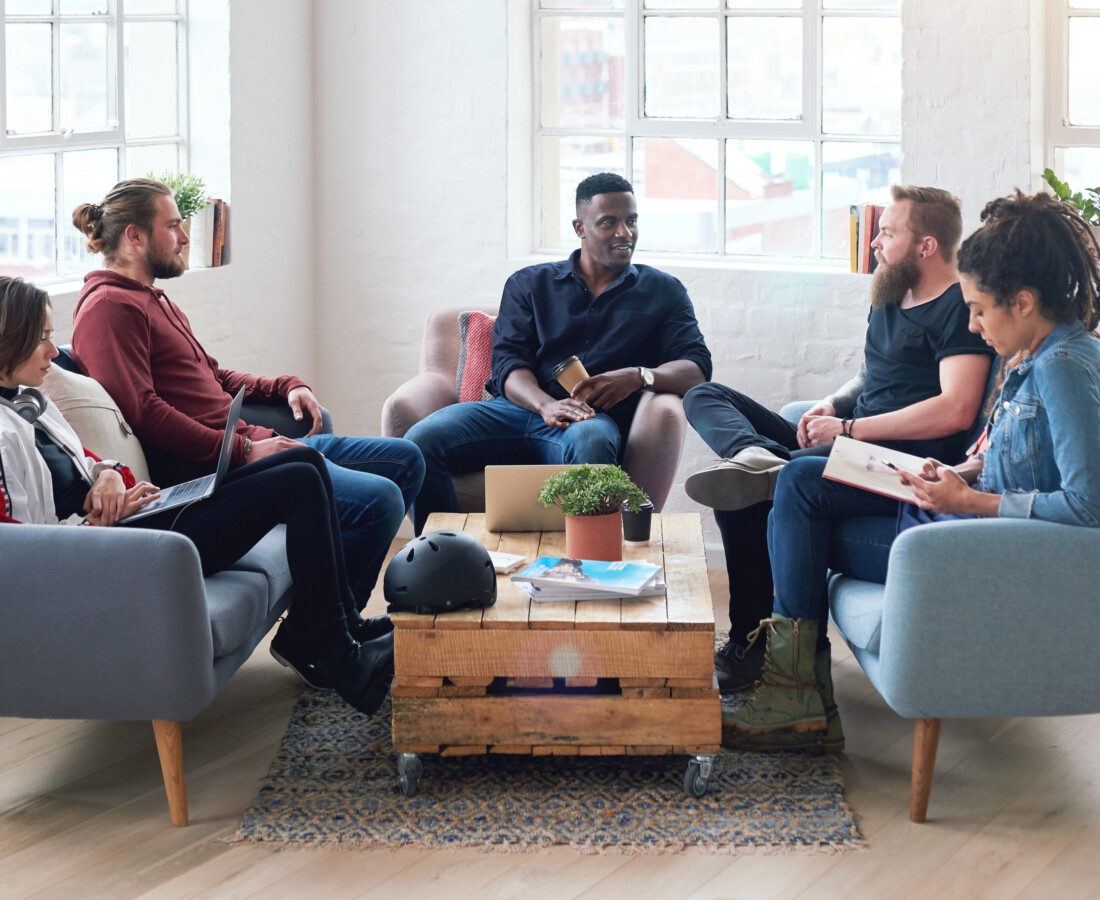 Group of adults sitting around a coffee table in discussion.