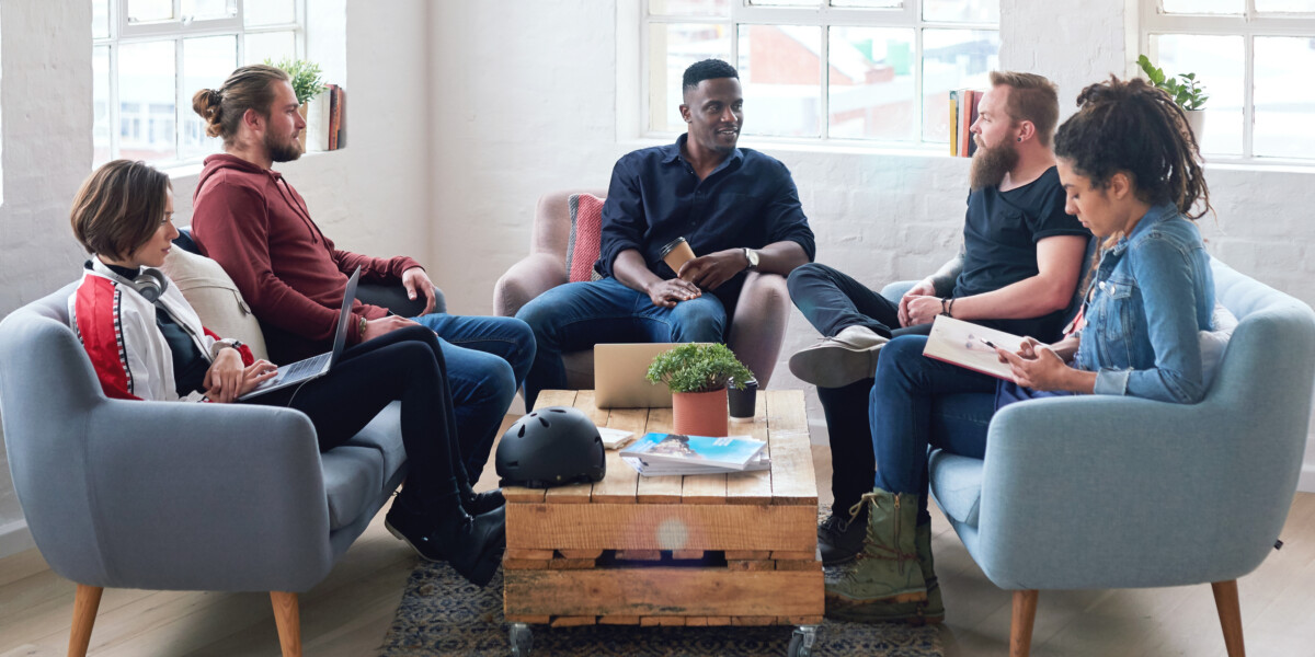 Group of adults sitting around a coffee table in discussion.