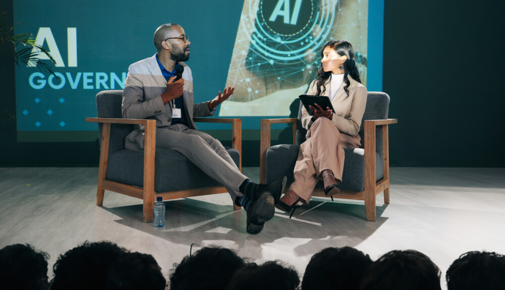 Event presentation and people with mic at stage for innovation speech or future development IT seminar and woman with man in conversation for ai governance machine learning or ethical guidelines