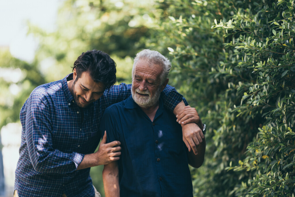 - UVM Professional and Continuing Education The old man and his son are walking in the park. A man hugs his elderly father. They are happy and smiling.