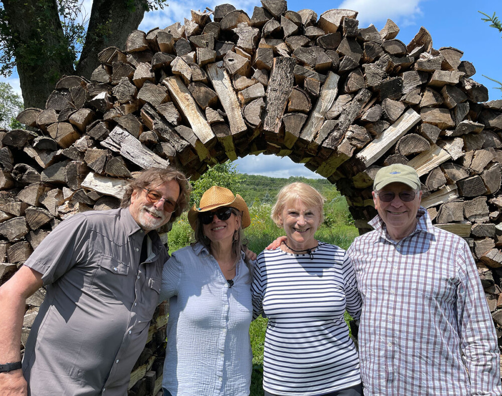 OLLI group photo in front of a wooden arch